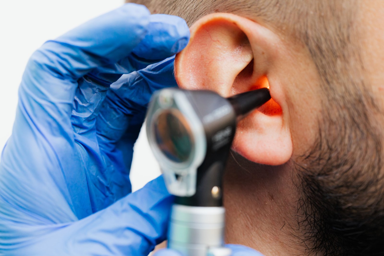 Audiologist testing patient ears using precision probe